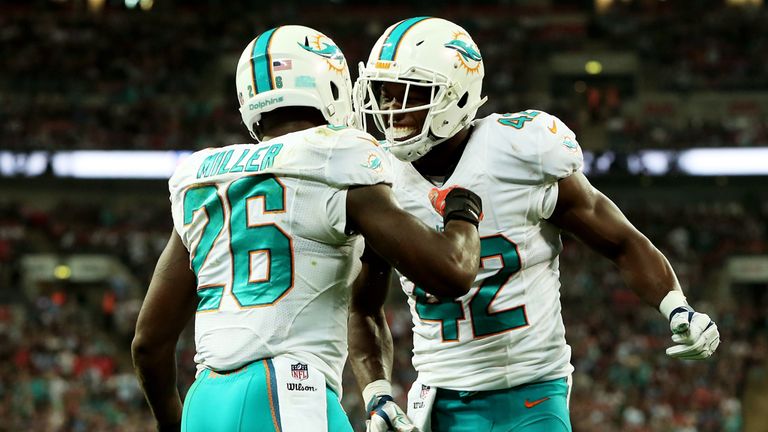 Lamar Miller #26 of the Miami Dolphins celebrates with teammate Charles Clay