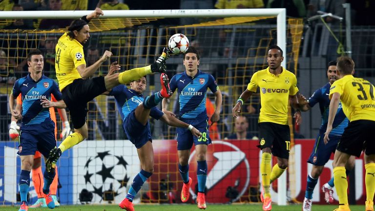 Alexis Sanchez (C) of Arsenal and Neven Subotic (L) of Borussia Dortmund  battle for the ball 