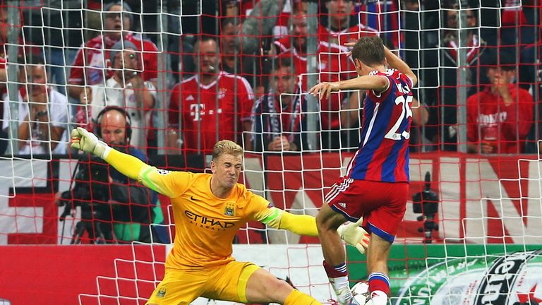 Joe Hart of Manchester City saves from Thomas Muller of Bayern Munich