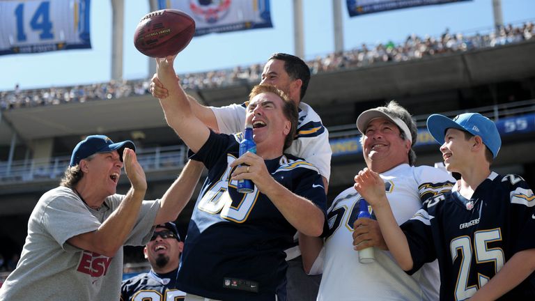 A fan celebrates after catching a kickoff during an NFL game