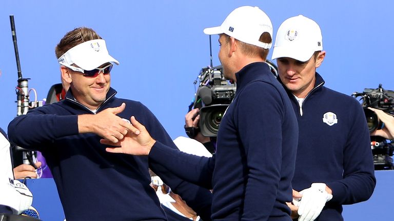 Ian Poulter shakes hands with European team-mate Henrik Stenson with Justin Rose lurking in the background