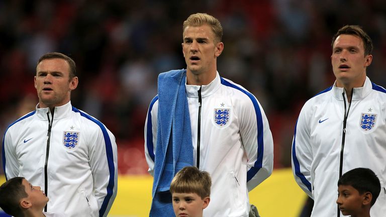 (left to right) England's Wayne Rooney, Joe Hart and Phil Jones sing the national anthem before the International Friendly at Wembley Stadium, London.