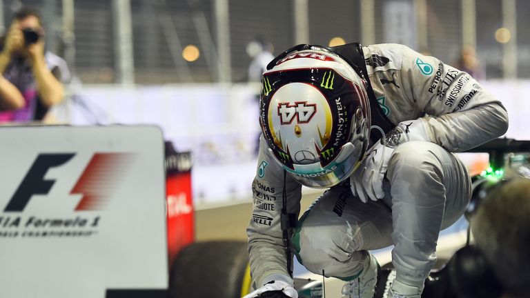 Lewis Hamilton pats his car as he celebrates in Parc Ferme