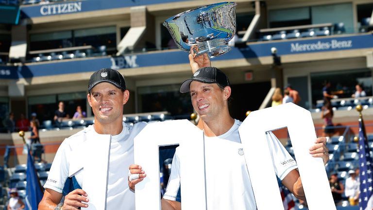 Mike Bryan and Bob Bryan pose with the champions trophy after their 100th career title win after defeating Marcel Granollers and Marc Lopez