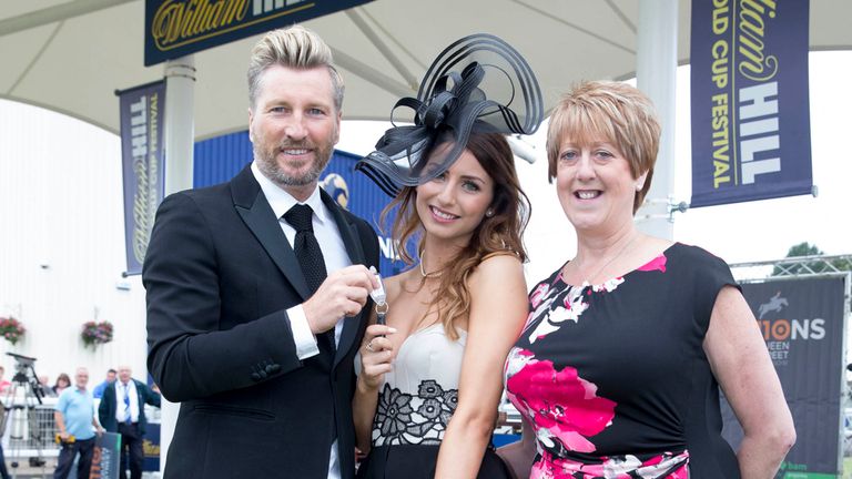 Robbie Savage hands over keys to Claire Young after she won the best dressed competition during day two of the 2014 William Hill Ayr Gold Cup Festival at A