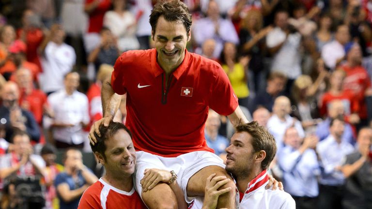 Switzerland's captain Severin Luethi (L) Stan Wawrinka (R) carry their teammate Roger Federer
