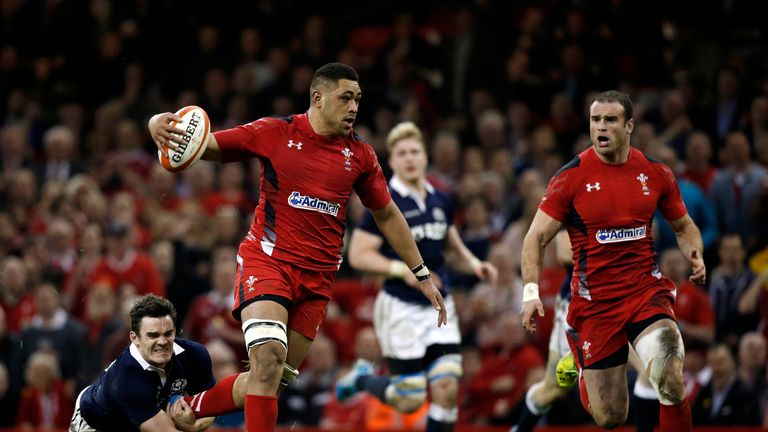 Wales' No 8 Toby Faletau (2nd L) breaks a tackle from Scotland's Max Evans (L) 