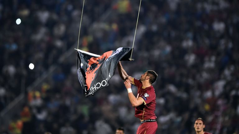 Serbia's defender Stefan Mitrovic grabs a flag with Albanian national symbols flown by a remotely operated drone