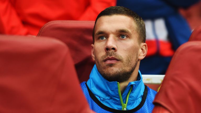 Lukas Podolski of Arsenal looks on from the substitutes bench before the UEFA Champions League Qualifier 2nd leg match against Besiktas