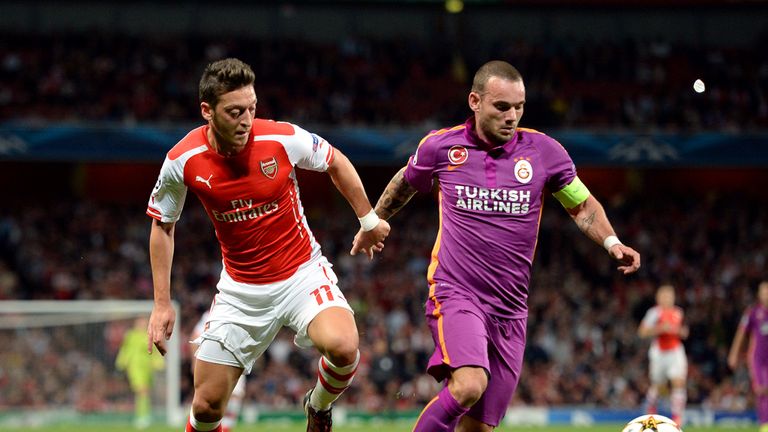 Arsenal's Mesut Ozil (left) and Galatasaray's Wesley Sneijder battle for the ball during the UEFA Champions League match at The Emirates Stadium