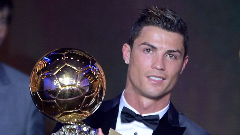 Real Madrid's Cristiano Ronaldo poses with the 2013 FIFA Ballon d'Or award for player of the year
