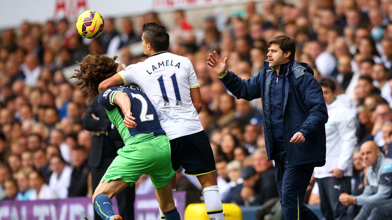 Erik Lamela battles for the ball with Fabricio Coloccini