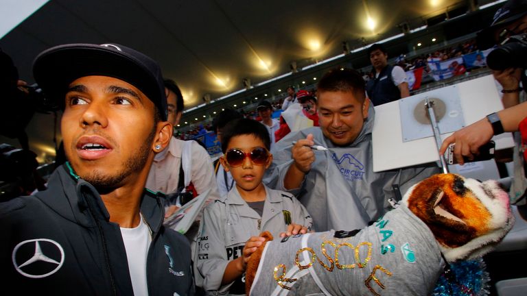 Lewis Hamilton meets a fan dressed as him complete with dog
