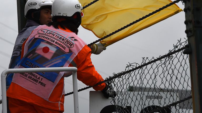 Marshals show the yellow flag and board for the safety car
