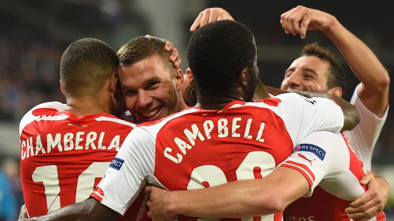 Lukas Podolski is mobbed by his team-mates after his late winner in Brussels