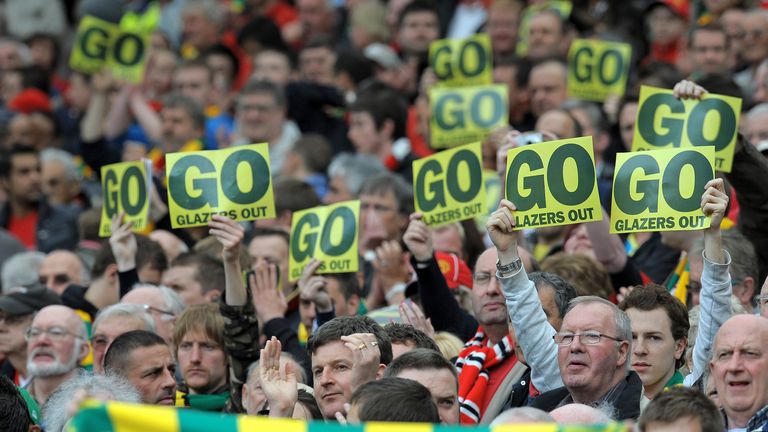 Supporters hold posters opposing Manchester United's US owner Malcolm Glazer before the match against Stoke City, May 2010