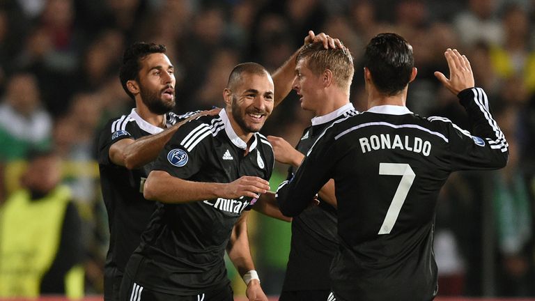 Real Madrid's French forward Karim Benzema (C) is congratulated by teammates