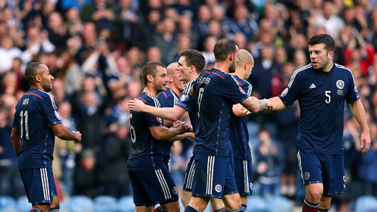 Shaun Maloney celebrates with his Scottish teammates after his shot went in off Akaki Khubutia of Georgia for an own goal. 