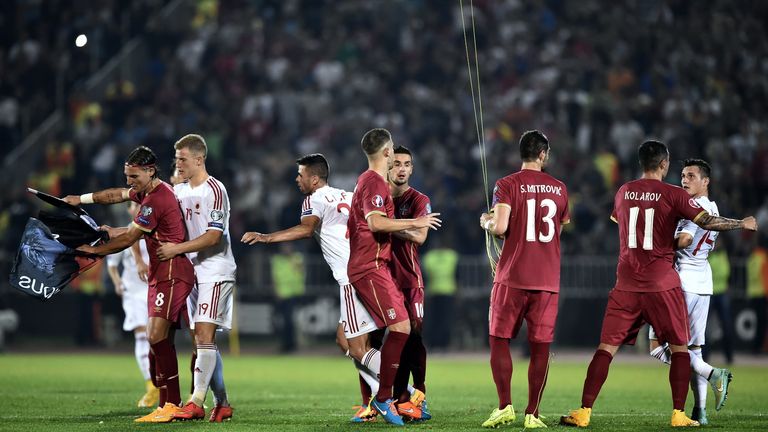 Serbia's and Albania players scuffle over a flag with Albanian national symbols pulled down by Serbia's defender Stefan Mitrovic (3rd R) from a drone