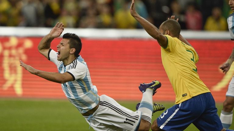 Brazilian João Miranda reacts as Argentinian Sergio Aguero falls while vying for the ball during the Superclasico football match Brazil versus Argentina