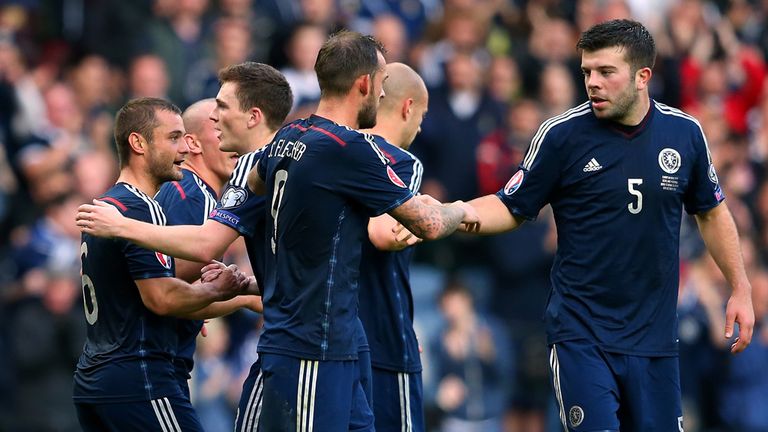 Shaun Maloney of Scotland celebrates with team mates after his shot went in off Akaki Khubutia of Georgia for an own goal 