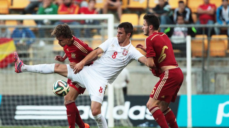 Aleksandar Pesic of Serbia (C) duels for the ball with Sergi Roberto Carnicer and Saul Niguez of Spain the 2015 UEFA European Under-21 Championship