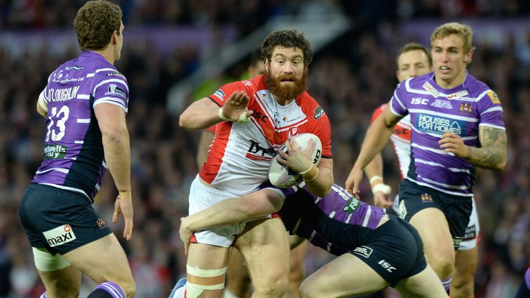 Kyle Amor of St Helens is tackled by Sean O'Loughlin and Liam Farrell of Wigan Warriors