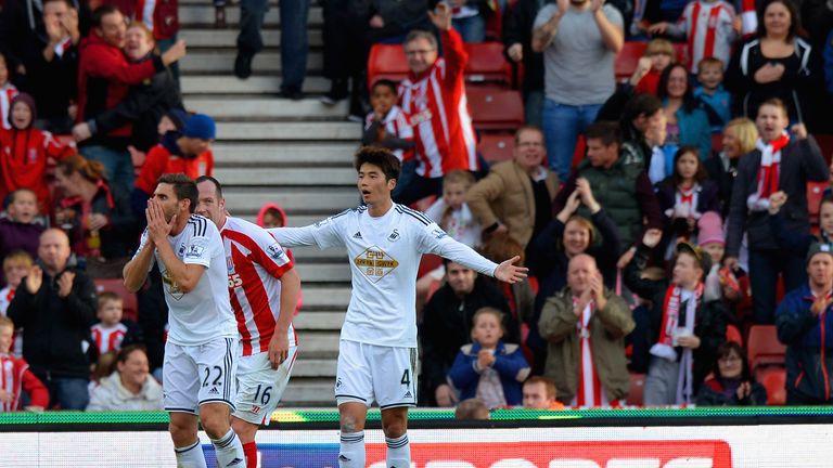 Victor Moses of Stoke City lies in the area as Angel Rangel of Swansea City (L) reacts after conceding a penalty