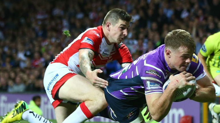 Joe Burgess (R) of Wigan scores the opening try despite the attentions of Mark Percival (L) of St Helens