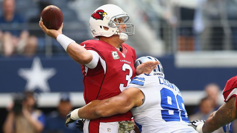Carson Palmer of the Arizona Cardinals throws while hit by  Tyrone Crawford of the Dallas Cowboys