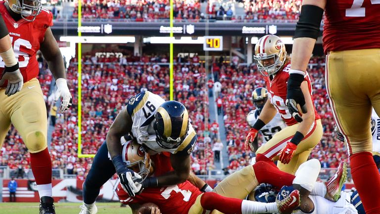 Colin Kaepernick of the San Francisco 49ers tackled in front of the goal line by Eugene Sims of the St. Louis Rams
