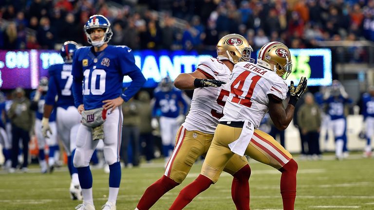 Antoine Bethea #41 and  Chris Borland #50 of the San Francisco 49ers celebrate an interception against  Eli Manning of New York Giants