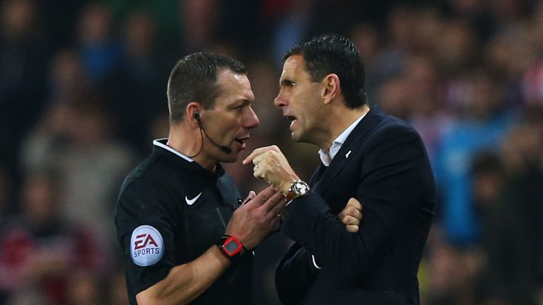 Referee Kevin Friend in discussion with Gustavo Poyet after he dismisses assistant Mauricio Taricco