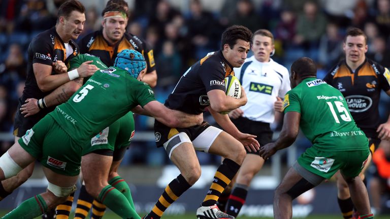 Alex Lozowski of Wasps is held by Dave Lyons of London Irish during the LV= Cup match
