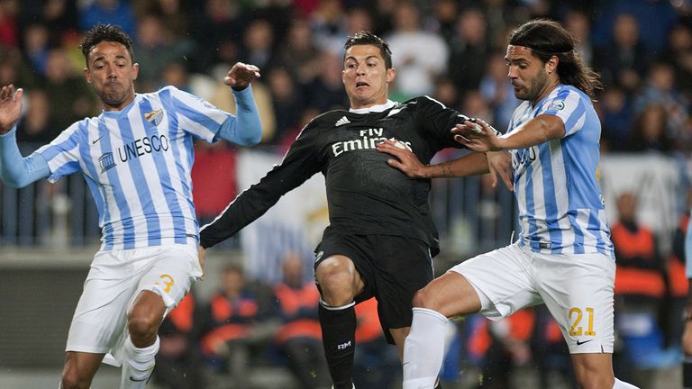 Real Madrid's Portuguese forward Cristiano Ronaldo (C) vies with Malaga's Brazilian defender Weligton (L) and defender Sergio Sanchez 