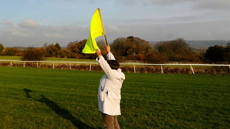 An advance flag operator in action on a British racecourse.