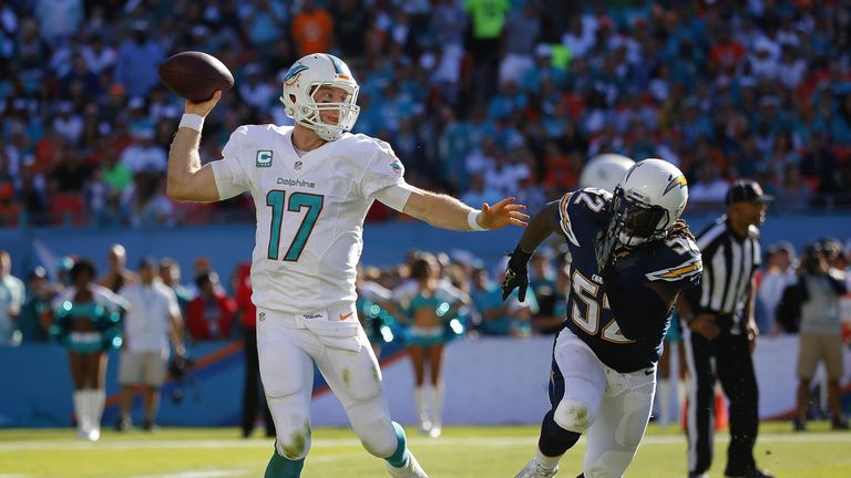 Quarterback Ryan Tannehill of the Miami Dolphins scrambles as he throws under pressure against the San Diego Chargers