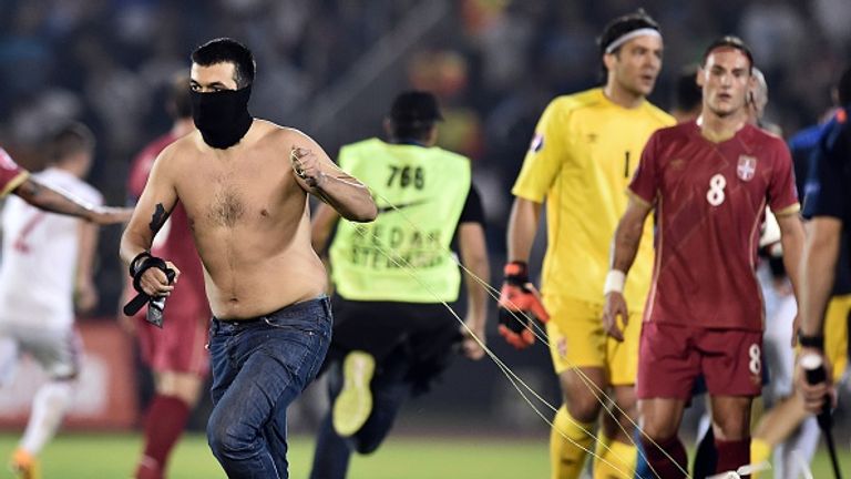 A masked Serbian supporter pulls the drone from the pitch