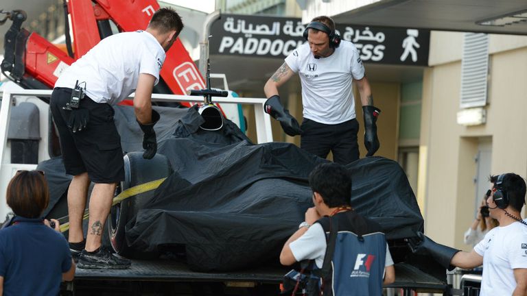 The McLaren is recovered to the pits