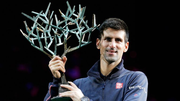 Novak Djokovic poses with the trophy after victory against Milos Raonic at the Paris Masters 2014