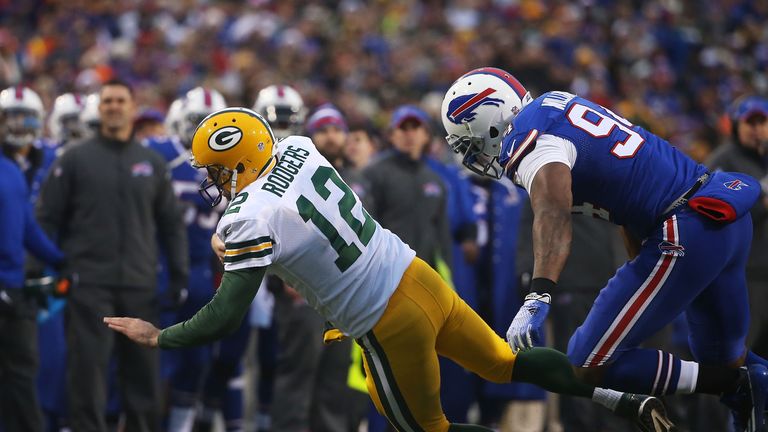 ORCHARD PARK, NY - DECEMBER 14:   Aaron Rodgers #12 of the Green Bay Packers is chased out of the pocket by Mario Williams #94 of the Buffalo Bills during 