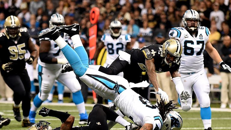 Kelvin Benjamin goes over the top of Saints' Pierre Warren to score a touchdown for the Panthers. 