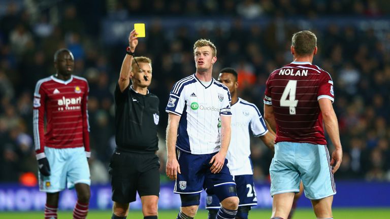 WEST BROMWICH, ENGLAND - DECEMBER 02: Referee Mike Jones shows Chris Brunt of West Brom a yellow card for a challenge on Kevin Nolan of West Ham  during th
