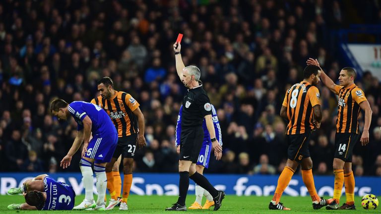 Referee Chris Foy shows a red card to Hull's Tom Huddlestoneafter a challenge on Filipe Luis