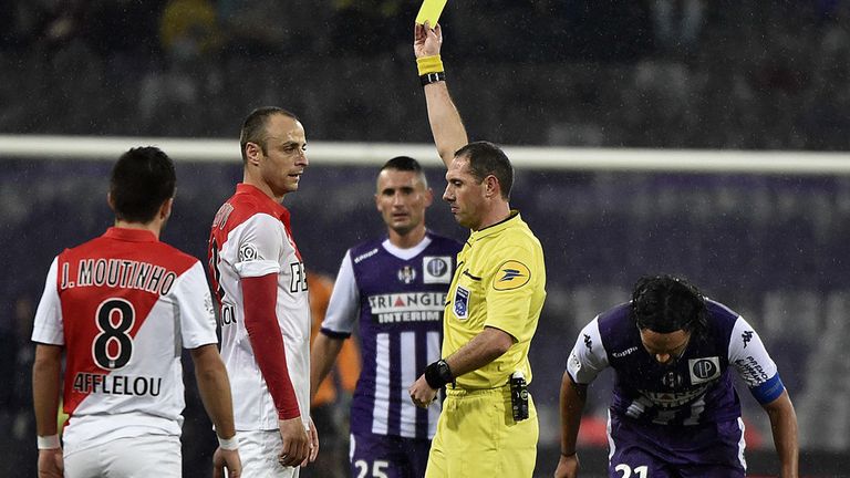 Monaco's Bulgarian forward Dimitar Berbatov (2nd L) gets a yellow card from French referee Mikael Lesage during the 