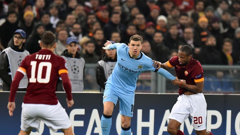 Manchester City striker Edin Dzeko (C) vies with Roma's Seydou Keita