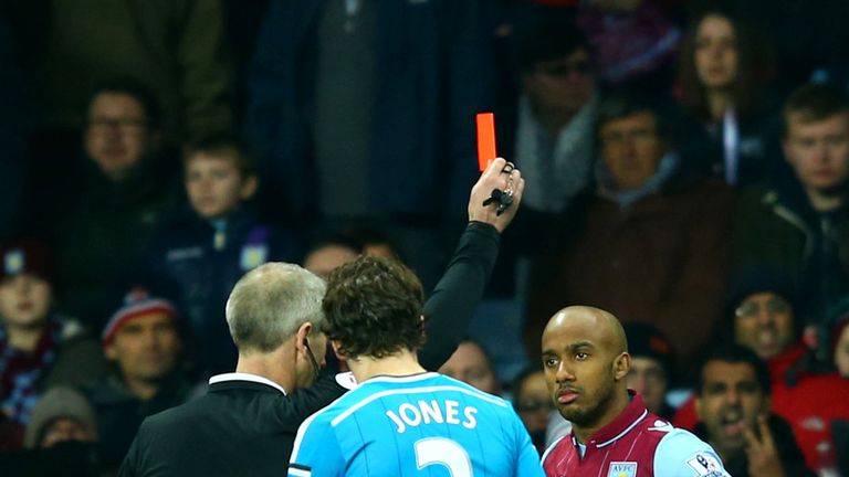 Fabian Delph of Aston Villa receives a red card from referee Martin Atkinson