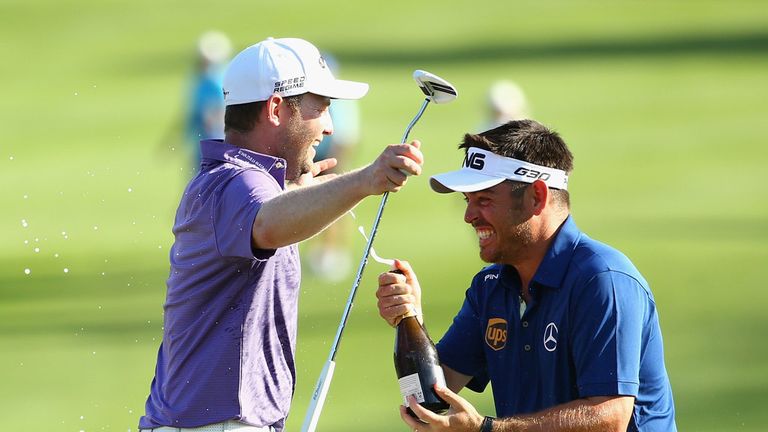 Branden Grace of South Africa is sprayed with champagne by Louis Oosthuizen of South Africa after securing victory in the Alfred Dunhill Championship