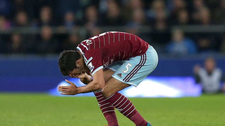 James Tomkins holds his face after clashing with Kevin Mirallas of Everton.