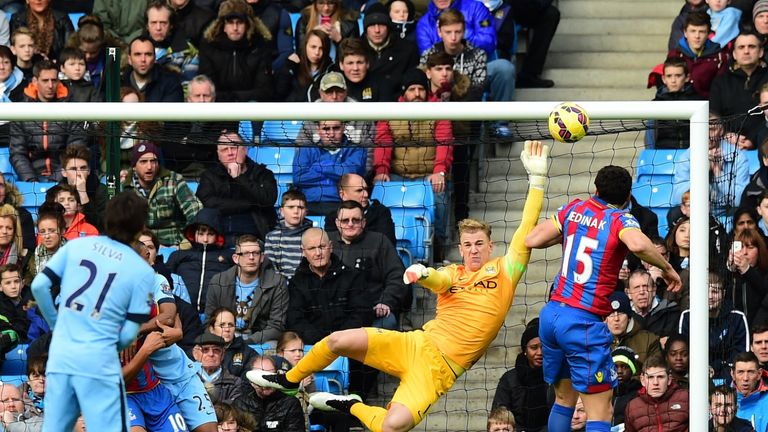 Manchester City's English goalkeeper Joe Hart (2nd R) makes a save from Crystal Palace's Australian midfielder Mile Jedinak (R)